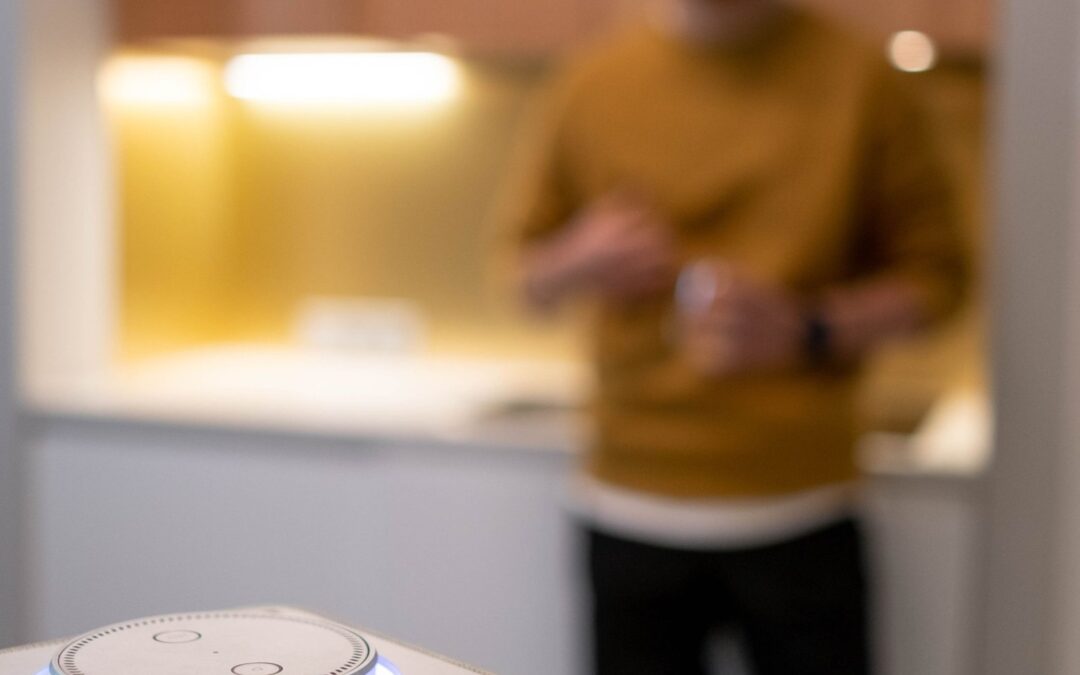 Man commanding a wireless smart speaker in a contemporary kitchen setting